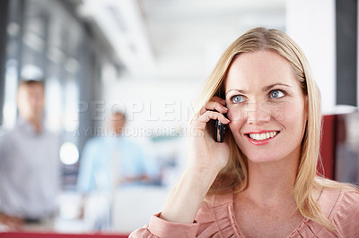 Buy stock photo A young professional talking on her cellphone while sitting in the office