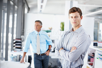 Buy stock photo Portrait of a young designer crossing his arms while a colleague stands in the background