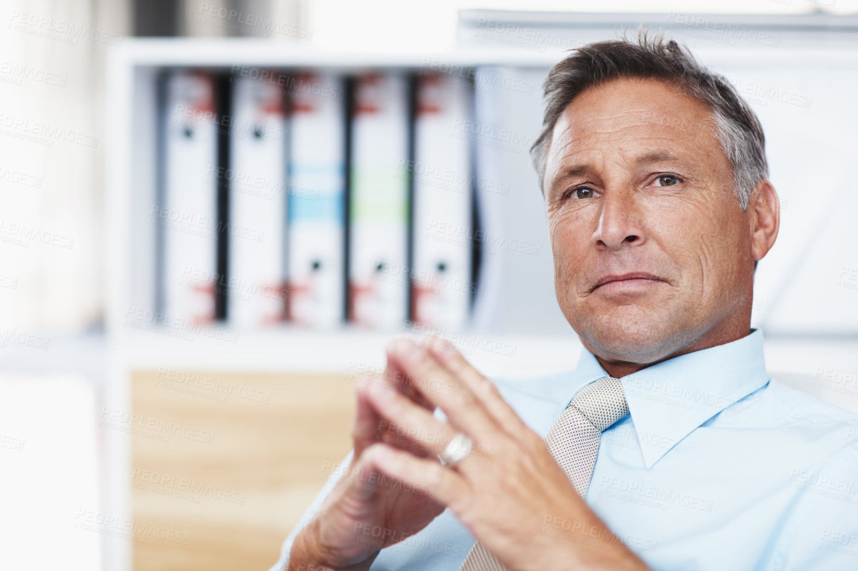 Buy stock photo Portrait of a respected business manager sitting at his desk with steepled hands