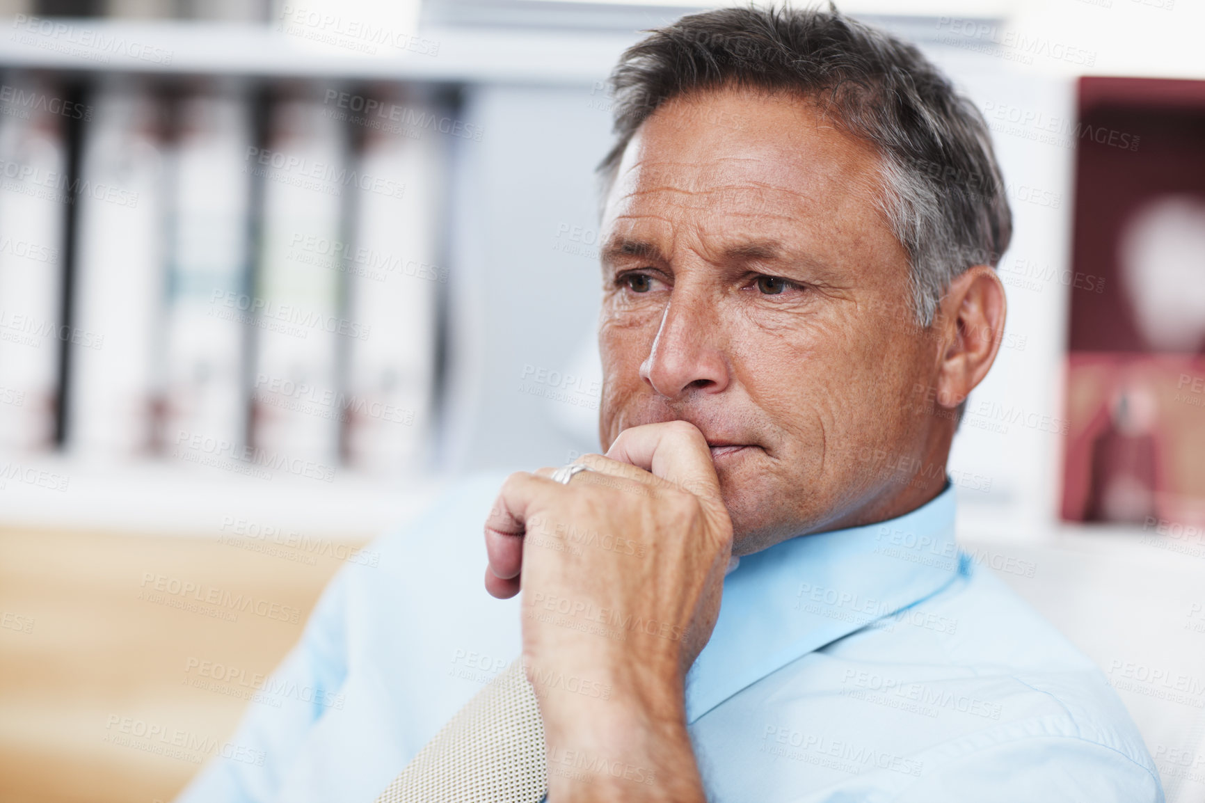 Buy stock photo A thoughtful business manager sitting at his desk and pondering a problem