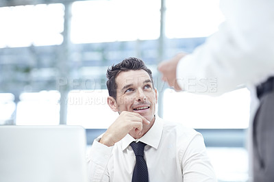 Buy stock photo A businessman sitting down and looking up to a colleague as they discuss business