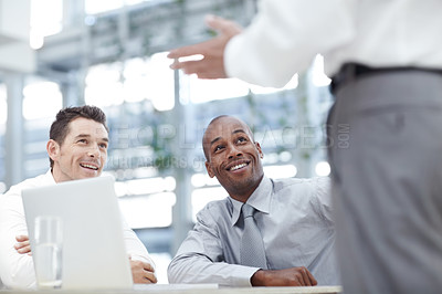 Buy stock photo Three businessmen in an office meeting together