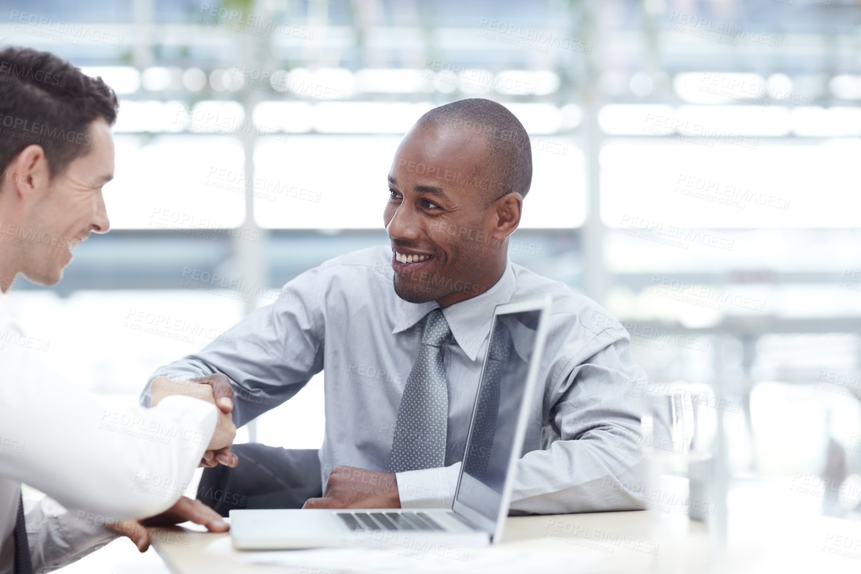 Buy stock photo Two businessmen shaking hands as they reach an agreement