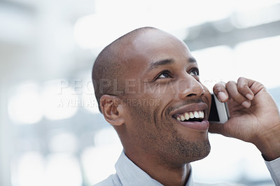 Buy stock photo A handsome african businessman, talking on his cellphone and laughing