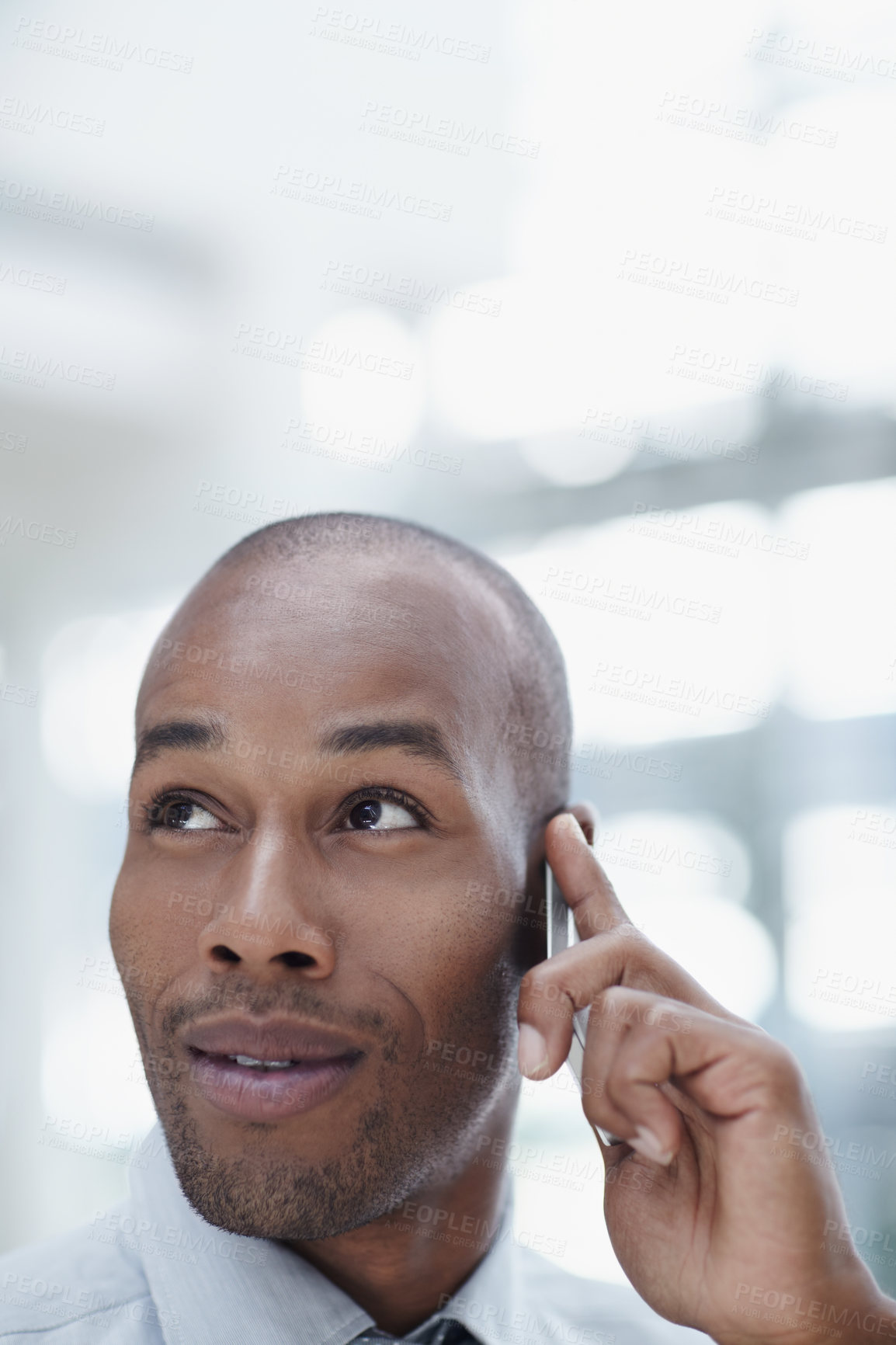 Buy stock photo A handsome African businessman, talking on his cellphone