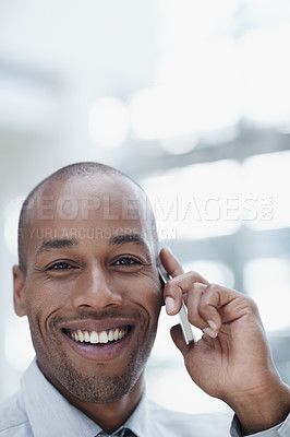Buy stock photo A handsome african businessman, talking on his cellphone and smiling