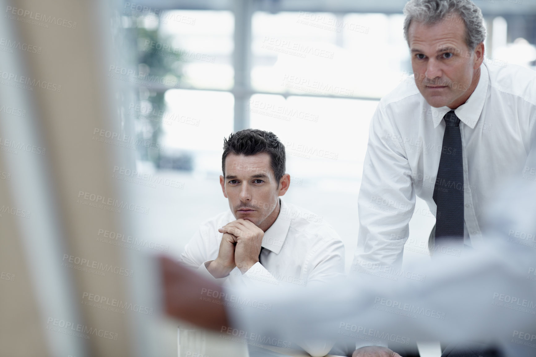 Buy stock photo Businessmen watch as a colleague delivers a presentation on a flipchart