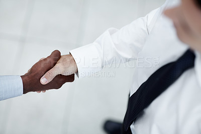 Buy stock photo A shot from above of a Caucasian man shaking hands with with a black businessman