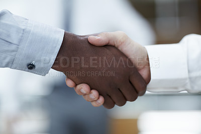 Buy stock photo Close up of a handshake between an African businessman and a Caucasian businessman