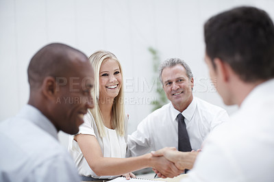 Buy stock photo Shot of a group of business people shaking hands in a meeting