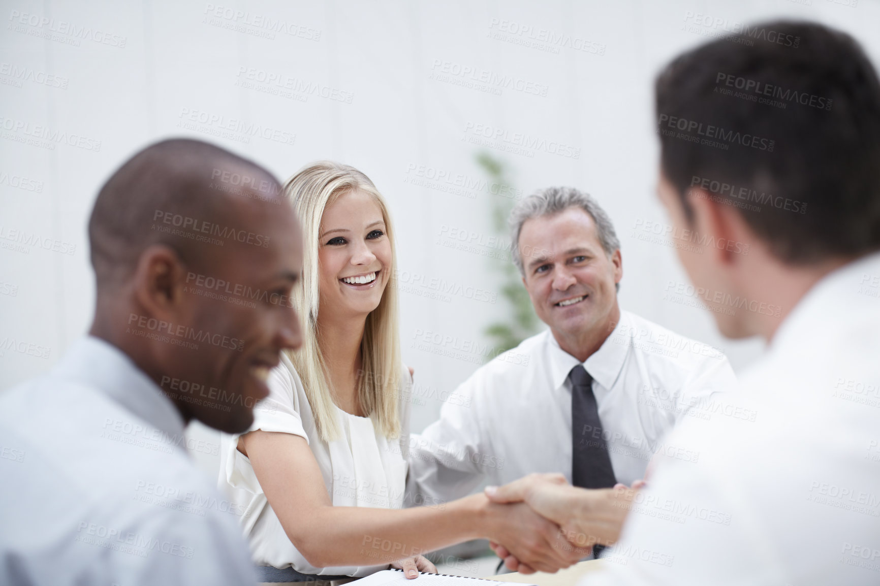 Buy stock photo Shot of a group of business people shaking hands in a meeting