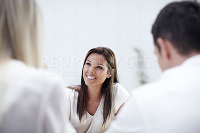 Buy stock photo A pretty financial advisor listening to her clients intently
