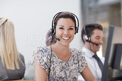 Buy stock photo Beautiful customer service representative smiling at the camera with colleagues working in background