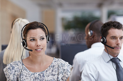 Buy stock photo A beautiful customer service representative with colleagues working in the background