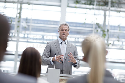 Buy stock photo A handsome senior businessman delivering an inspiring speech from the podium