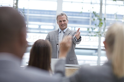 Buy stock photo A handsome senior executive seeking his colleagues' input while delivering a speech at a seminar
