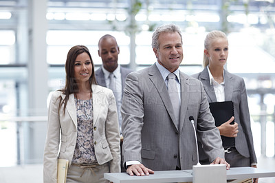Buy stock photo A team of experienced businesspeople pitching to their colleagues from a podium