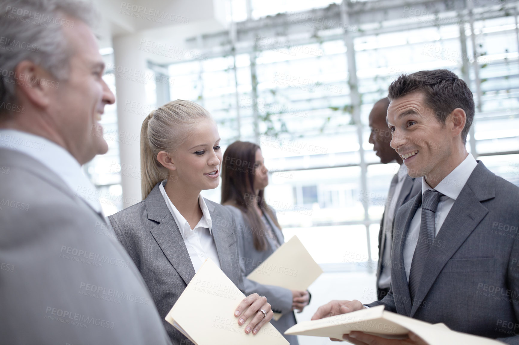 Buy stock photo A diverse group of happy-looking executives talking about a report together