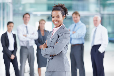 Buy stock photo Happy young African businesswoman standing with her coworkers behind her - portrait 