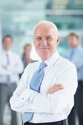 Buy stock photo Confident senior businessman standing with his team in the background - portrait 