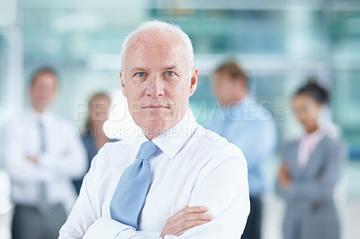 Buy stock photo Senior businessman standing with his team in the background - portrait 