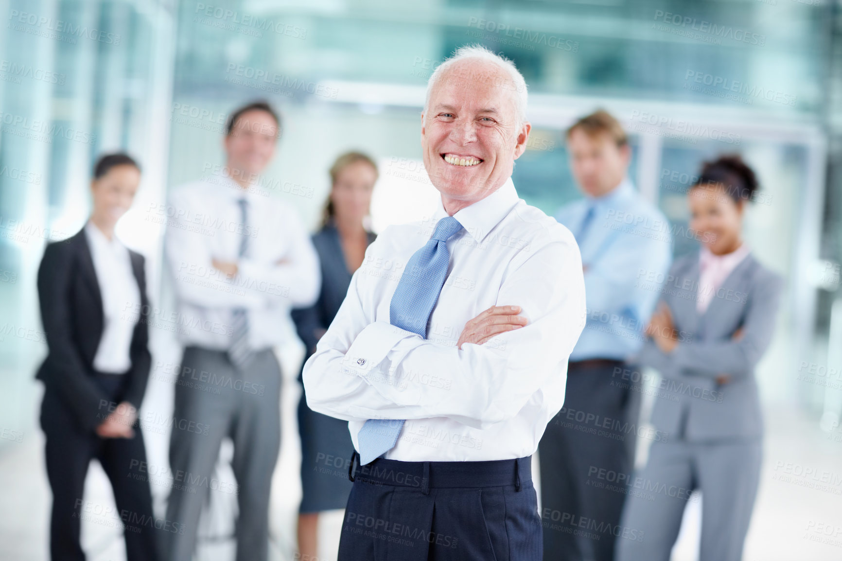 Buy stock photo Happy senior businessman standing with his team in the background - portrait 