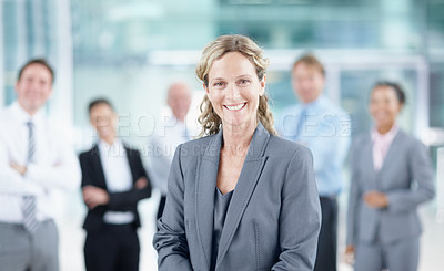 Buy stock photo Smiling mature businesswoman with her business team behind her - portrait 
