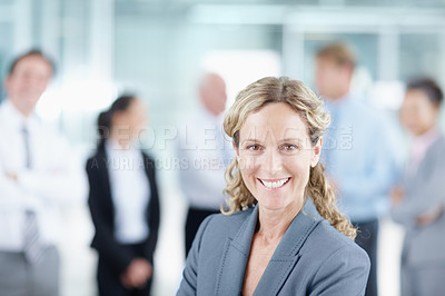 Buy stock photo Positive mature businesswoman with her business team behind her - portrait 