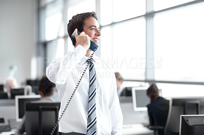 Buy stock photo Young business executive standing in the office while on the phone 