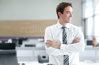 Buy stock photo Young business executive standing in the office looking confident with his arms folded 
