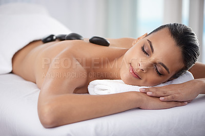 Buy stock photo Zen, hot stone and woman with massage at spa for wellness, health and back treatment. Self care, cosmetic and young female person sleeping for warm stone back therapy at natural beauty salon.