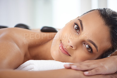 Buy stock photo Portrait, hot stone and woman with massage for relaxing at spa for wellness, health and back treatment. Self care, cosmetic and female person with warm stone back therapy at natural beauty salon.