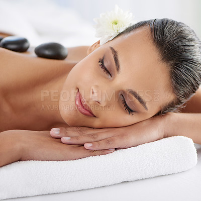 Buy stock photo Zen, hot stone and woman with massage at spa for wellness, health and back treatment. Self care, cosmetic and young female person sleeping for warm rock skin therapy at natural beauty salon.