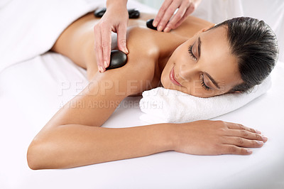 Buy stock photo Hot stone, woman and hands massage shoulder for skincare, beauty and pamper body for wellness at luxury salon. Back, rocks and happy person at spa for treatment, relax or health with masseuse
