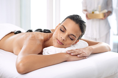 Buy stock photo Nap, hot stone and woman with massage at spa for wellness, health and back treatment. Self care, cosmetic and young female person sleeping for warm rock skin therapy at natural beauty salon.