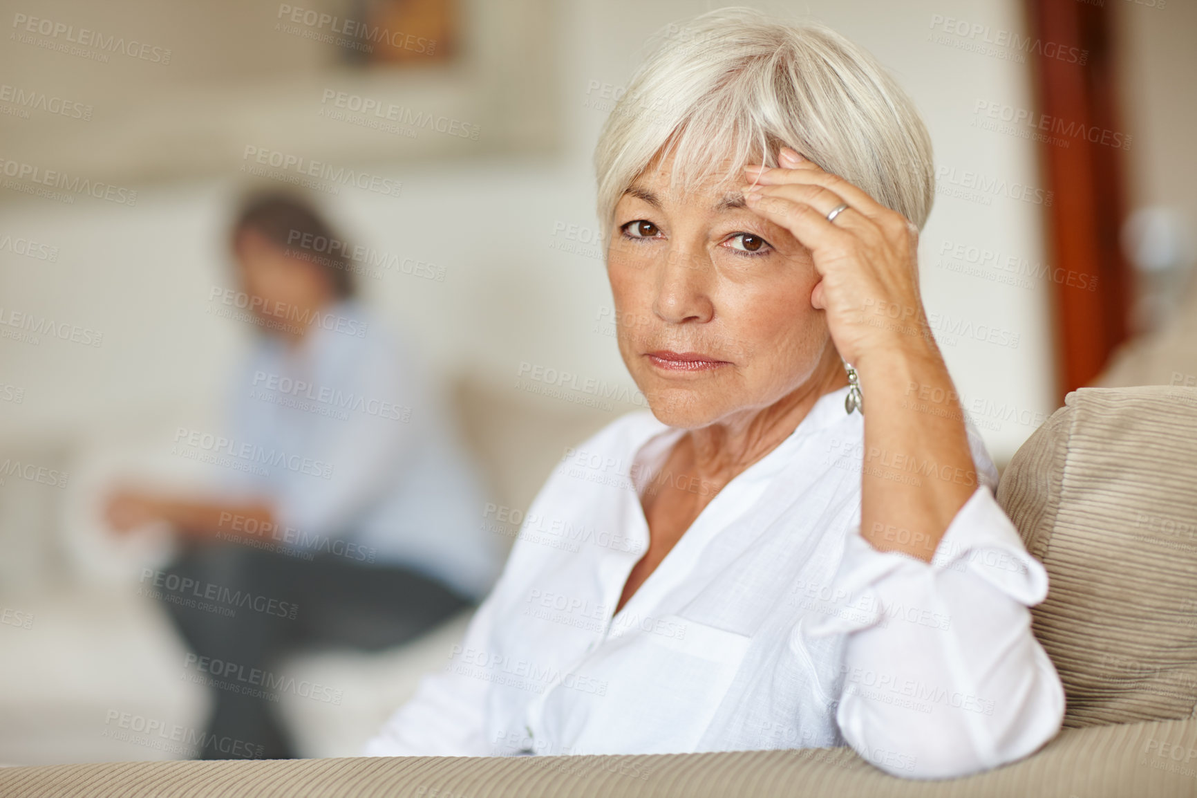 Buy stock photo Shot of a senior woman looking sad while sitting on the sofa at home