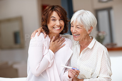 Buy stock photo Shot of a woman celebrating her pregnancy test result with her mother