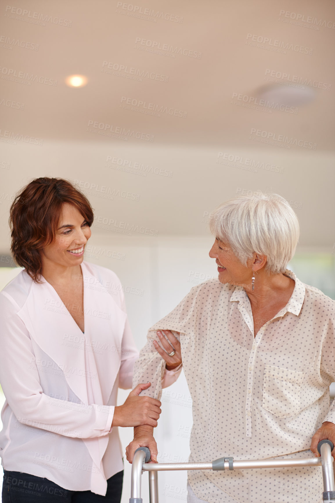 Buy stock photo Shot of a woman assisting her elderly mother with an orthopedic walker