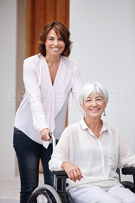 Buy stock photo Shot of a woman pushing her elderly mother in a wheelchair