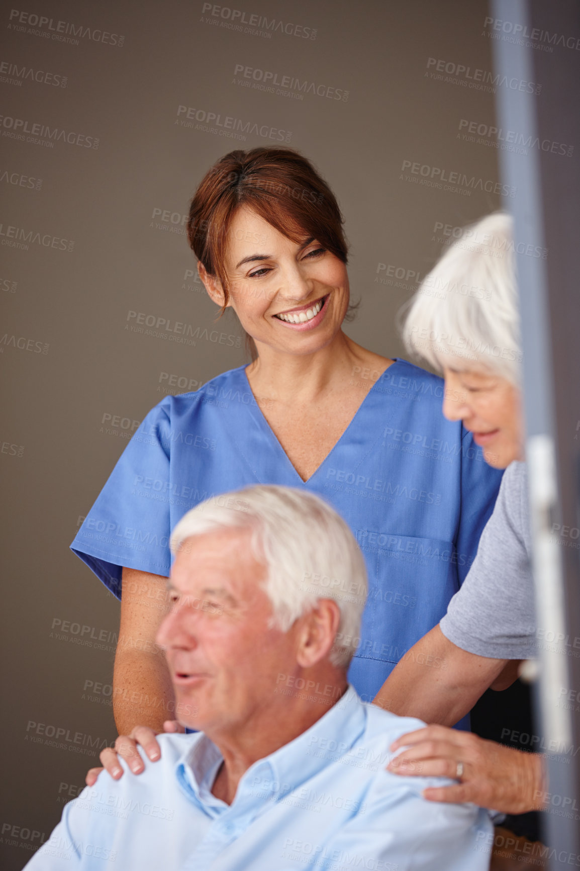 Buy stock photo Cropped shot of a female nurse standing by her senior patient and his wife