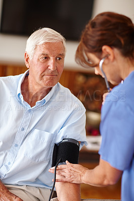 Buy stock photo Shot of a doctor checking a  senior patient's blood pressure