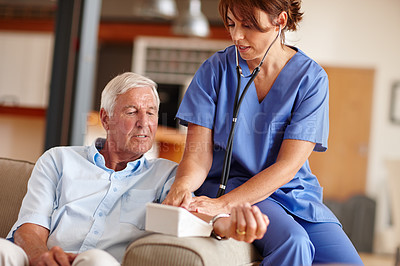 Buy stock photo Shot of a doctor checking a  senior patient's blood pressure
