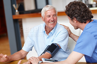 Buy stock photo Shot of a doctor checking a senior patient's blood pressure