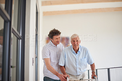 Buy stock photo Shot of a man assisting his elderly father with an orthopedic walker