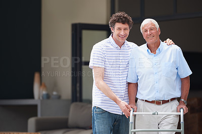 Buy stock photo Shot of a man assisting his elderly father with an orthopedic walker