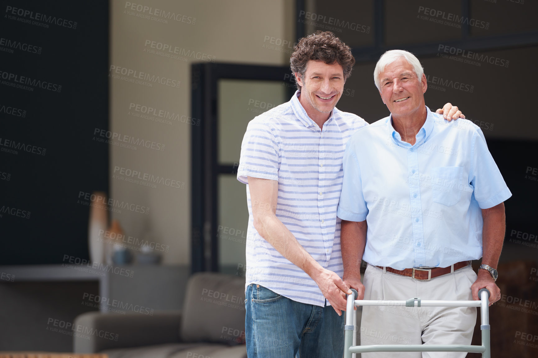 Buy stock photo Shot of a man assisting his elderly father with an orthopedic walker