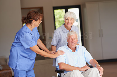 Buy stock photo Cropped shot of a nurse standing by her senior patient and his wife