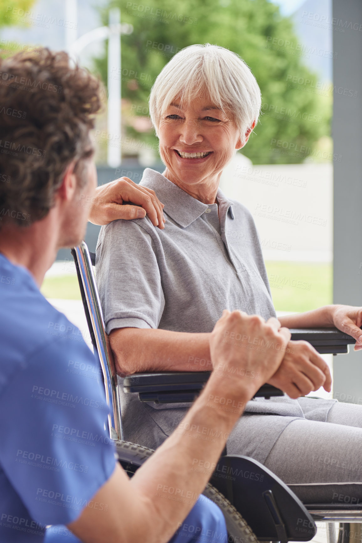 Buy stock photo Shot of a happy senior woman in a wheelchair talking with her doctor