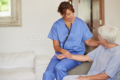 Buy stock photo Cropped shot of a female nurse checking on a senior patient