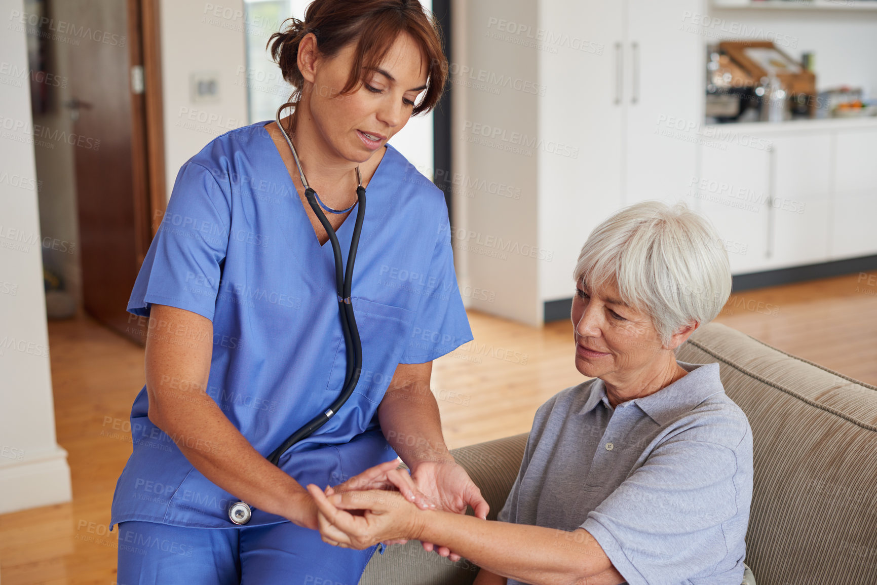 Buy stock photo Cropped shot of a female nurse checking on a senior patient